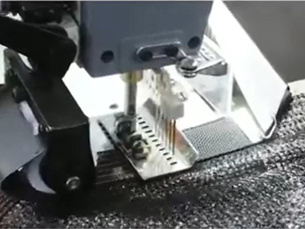 The machine is sewing the plastic net edges for reinforcement.